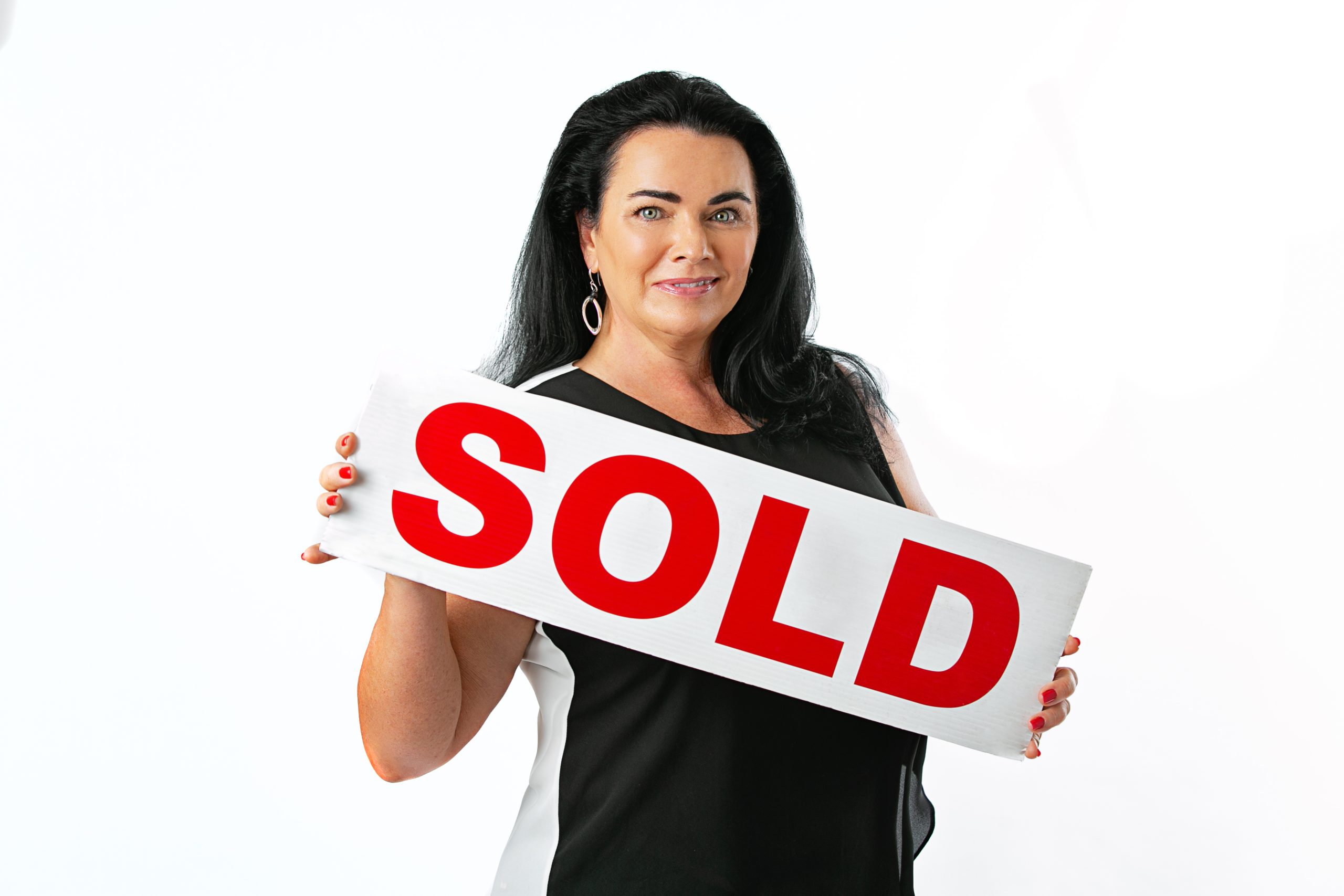 Realtor Donna Jarock holding a SOLD sign after selling a home in Aurora CO