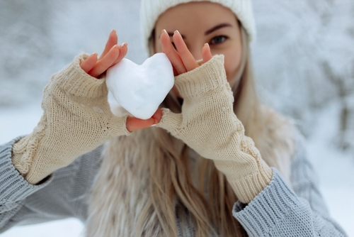 Cozy winter scene with a snow globe and hot cocoa that reflects the charm of holiday movie towns.