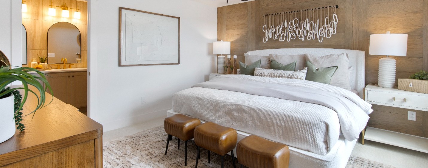 Primary bedroom inside a low maintenance single family home in Aurora, Colorado with modern design, warm wood accents, and an attached bathroom.